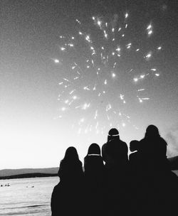 Low angle view of silhouette people standing at beach against sky