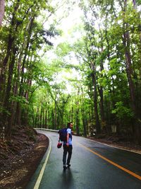 Rear view of woman walking on road
