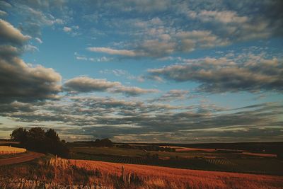 Scenic view of field against cloudy sky