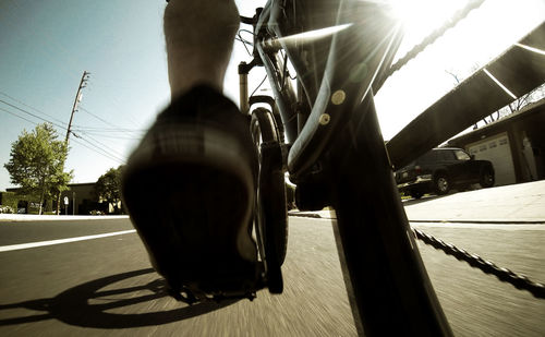 Close-up of cropped bicycle moving on road