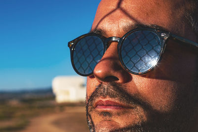 Close-up portrait of young man wearing sunglasses