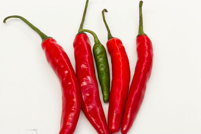 Close-up of red chili peppers against white background