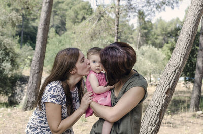 Mother and daughter standing on tree