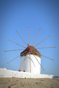 Low angle view of traditional windmill against blue sky