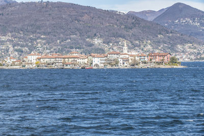 Scenic view of sea by town against mountain