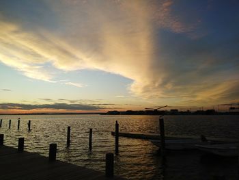 Pier over sea against sky during sunset