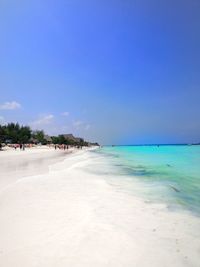 Scenic view of beach against blue sky