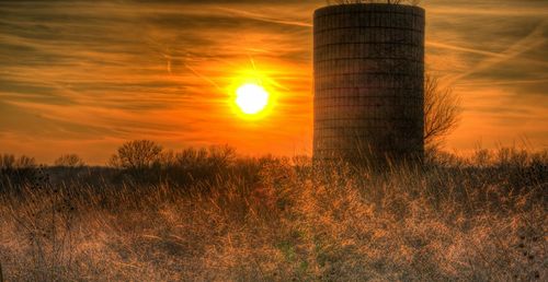 Scenic view of field against sky at sunset