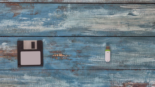 Close-up of floppy disc and usb stick on wooden table