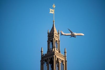 Low angle view of clock tower against clear blue sky