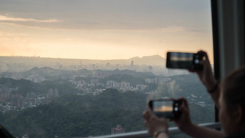 Man photographing cityscape seen through camera