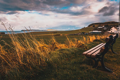 Lonely bench in a cold and windy coastal city, pointing to the sea with dramatic cloudy sky