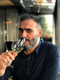Portrait of man drinking wine at restaurant