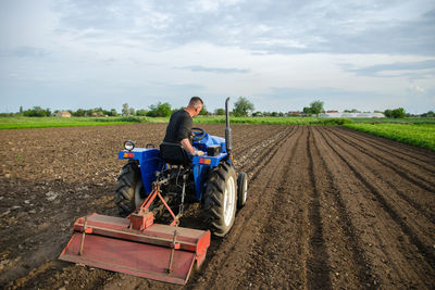 A farmer cultivates a field with a tractor after harvest. milling soil, crushing before cutting rows