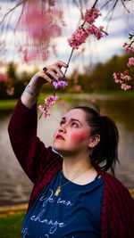 Side view of young woman holding autumn leaves