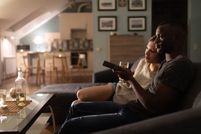 Young woman using mobile phone while sitting on sofa