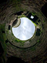 Low angle view of old stone wall against sky