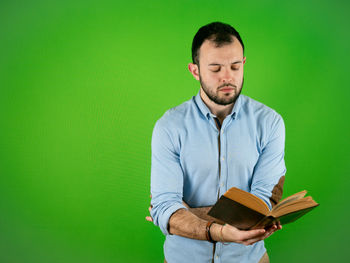 Portrait of young man standing on book