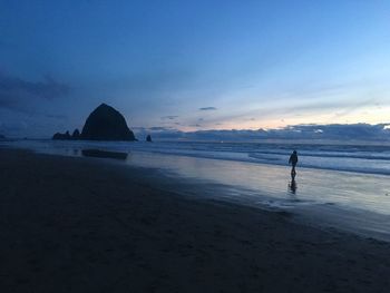 Scenic view of beach against sky at sunset