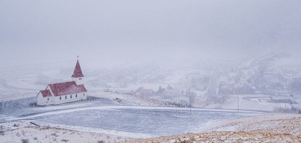 Vik i myrdal church during heavy snow at the village of vik in iceland in winter.