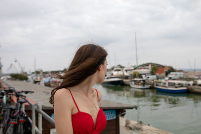 Woman looking at sailboat against sky