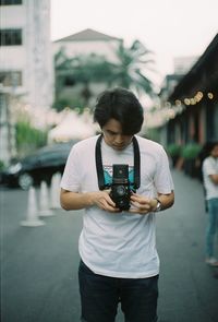 Full length of man photographing on street