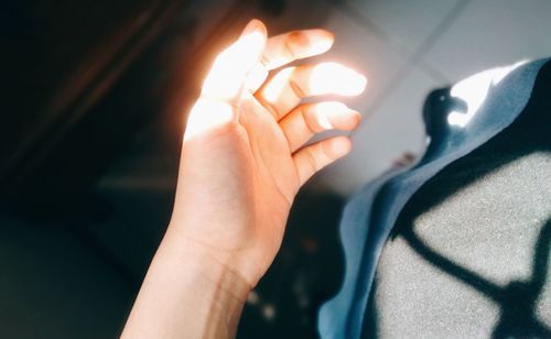 Close-up of woman hand holding illuminated candles