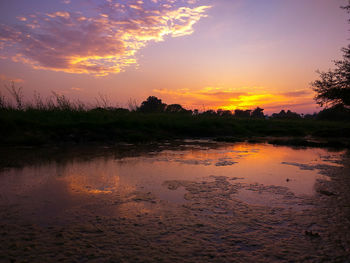 Scenic view of lake against orange sky