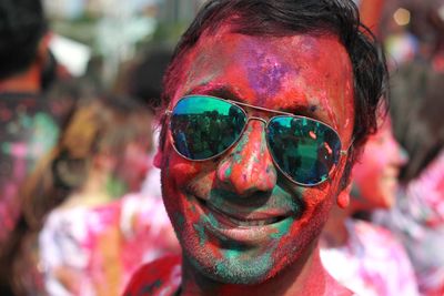 Portrait of smiling man with powder paint on face during holi