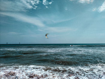 Man parasailing in sea against sky