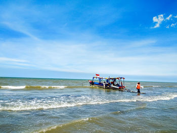 People on beach against sky