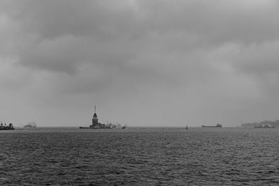 View of sailboat in sea against cloudy sky