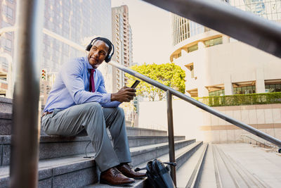 Portrait of young man sitting on railing