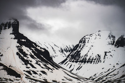 Close-up of snow covered mountain against cloudy sky