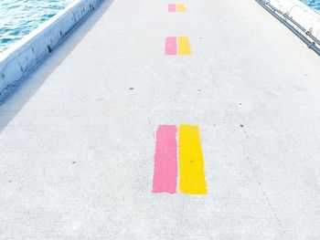 High angle view of yellow and pink paint marking on road