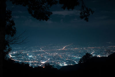 High angle view of illuminated cityscape against sky at night