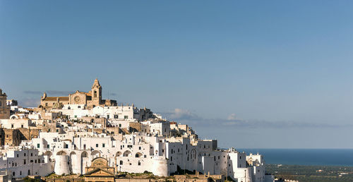 Buildings in city against clear sky