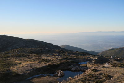 Scenic view of river by mountains against clear sky