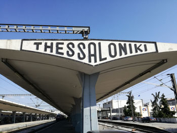 Low angle view of information sign against clear blue sky