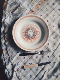 Directly above shot of bowl with fork and knife on table