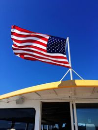 Low angle view of flag against blue sky