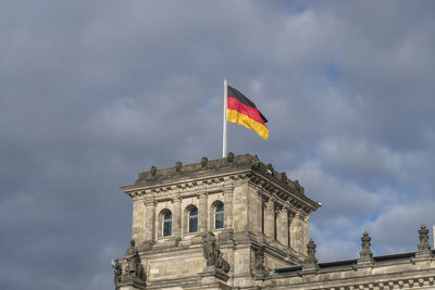 Low angle view of flag against cloudy sky