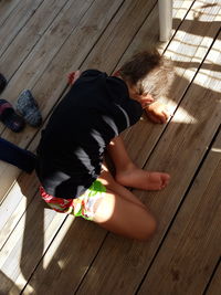 High angle view of boy sitting on hardwood floor