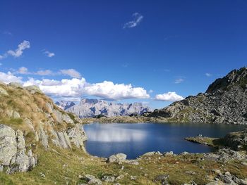 Scenic view of lake and mountains against blue sky