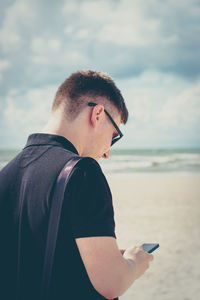 Man using mobile phone at beach