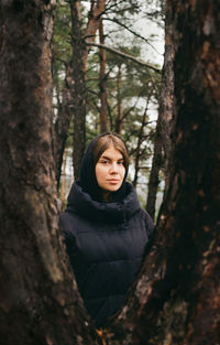 Portrait of woman by tree in forest