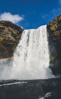 Scenic view of waterfall against sky