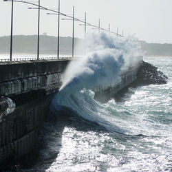 Water splashing in sea against sky