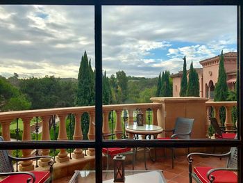 Chairs and table in balcony against sky