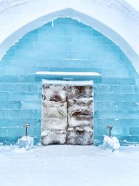 Snow covered field by building